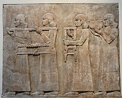 Neo-Assyrian relief depicting eunuchs carrying booty from a war