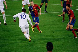 Rooney takes on Andrés Iniesta and Sergio Busquets of Barcelona during the 2009 UEFA Champions League final.