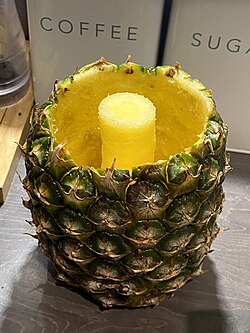 A hollowed-out pineapple with its core left intact, ready for filling, e.g., with other fruits.